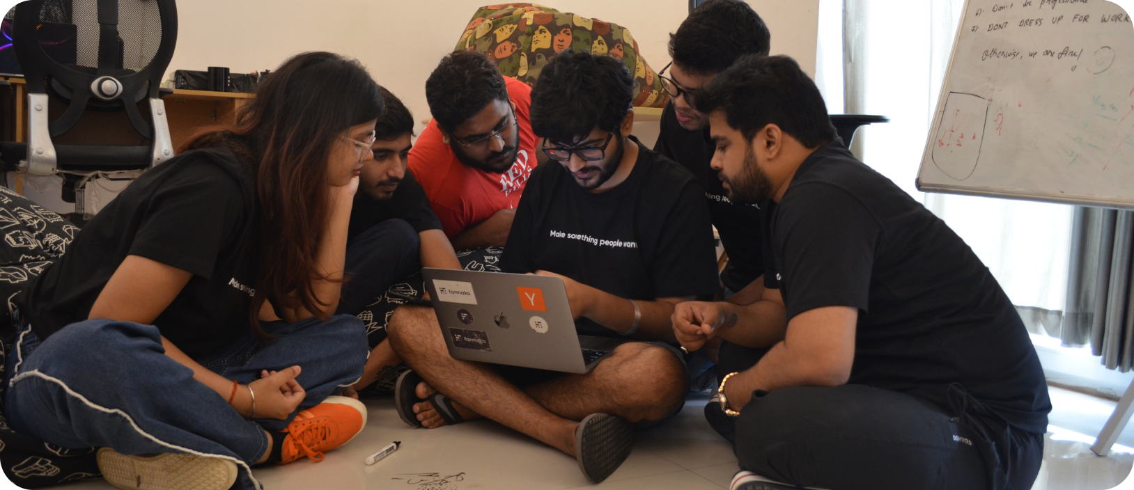 Farmako team huddled around a laptop