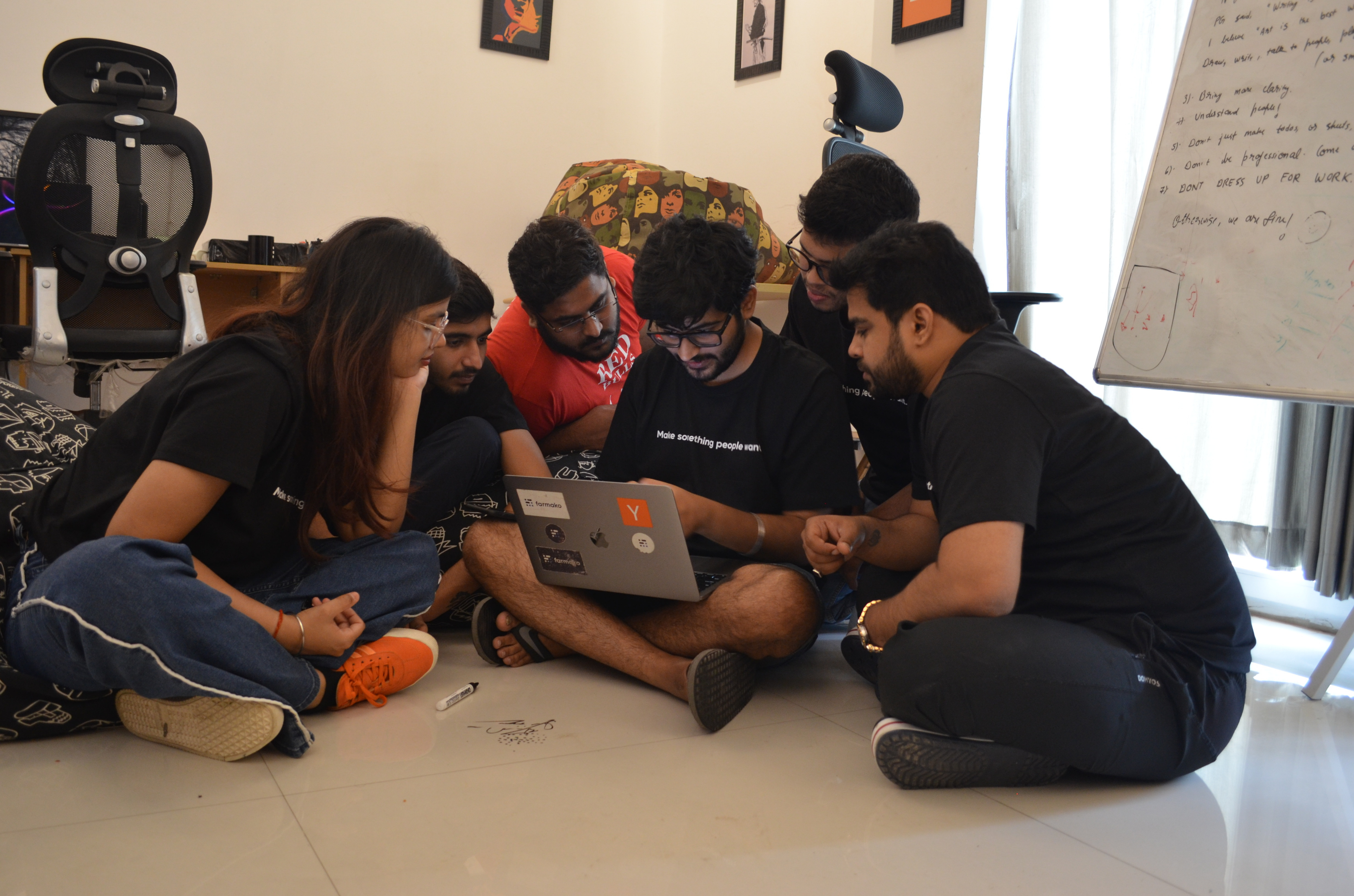 Farmako team gathered around a laptop